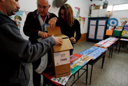 Las autoridades electorales revisar una de las urna de votación para las elección primaria abierta en Buenos Aires.