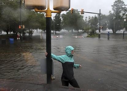 Una mujer camina por una calle inundada en New Bern (Carolina del Norte).