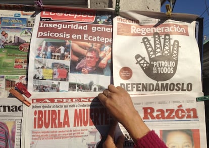 Una quiosquera despliega en una calle de Ecatepec los periódicos del día. Los diarios de sucesos, o de 'nota roja', como les llaman en México, tienen en este municipio una fuente de información permanente.