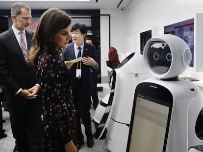 Los reyes de España, Felipe VI y Letizia, observan un robot durante su visita a un centro tecnológico de Seúl.