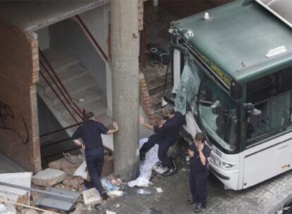 El autobús, empotrado contra el edificio ayer al mediodía en el barrio del Carmel de Barcelona.