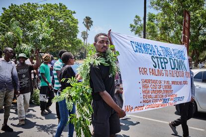 Un joven sostiene una pancarta en oposición al presidente Lazarus Chakwera durante una protesta en Blantyre contra la reciente devaluación del 44% de la moneda local frente al dólar estadounidense.