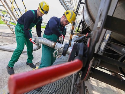 Dos trabajadores recibían el jueves aditivo líquido para el refinado de petróleo de un tren cisterna, al sur de Budapest (Hungría).