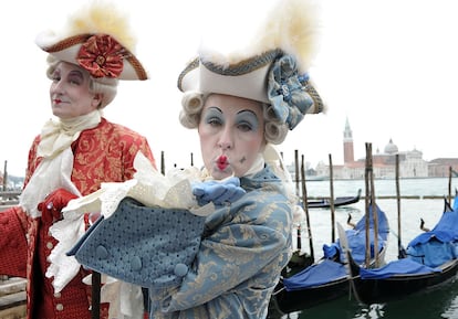 Dos personas con indumentaria clásica del Carnaval veneciano posan en la plaza San Marcos.