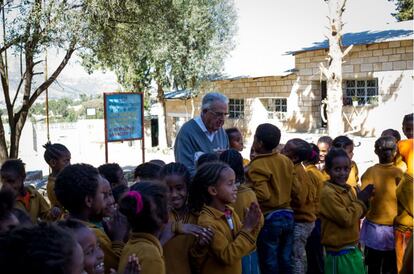 El padre Roca charla con algunos alumnos del colegio vecino a Don Bosco mientras otros hacen cola para obtener su vaso de leche diario.