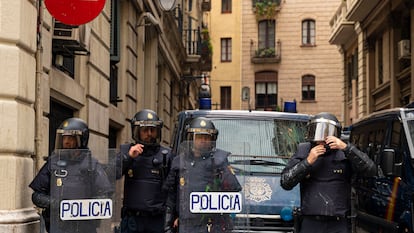 Policías nacionales se preparan para acordonar el paso de una manifestación.