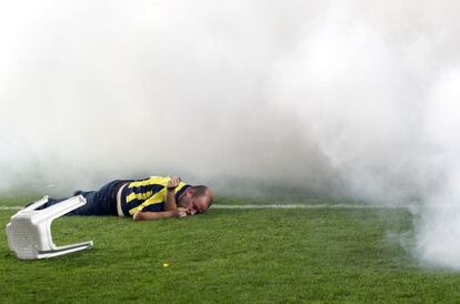 Un aficionado del Fenerbahce, tendido en el suelo tras en lanzamiento masivo de bengalas.