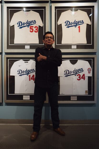 The pitcher poses with his #34 jersey, hanging next to those of Pee Don Drysdale (#53), Wee Reese (#1) and Gil Hodges (#14).
