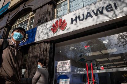 En esta foto de archivo tomada el 22 de abril, la gente pasa frente a una tienda de Huawei en Beijing.