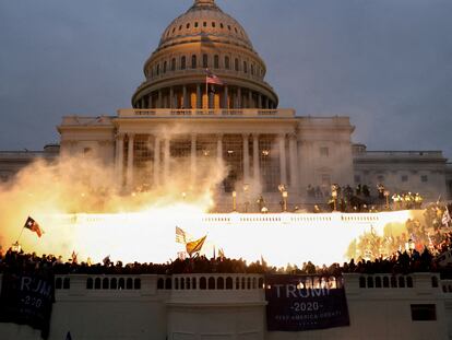 An explosion caused by a police munition is seen while supporters of Donald Trump riot in front of the US Capitol Building in Washington January 6, 2021.