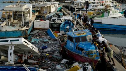 Pescadores intentan mover un barco dañado tras el paso del huracán Beryl en el puerto de Bridgetown, Barbados.