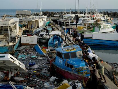 Pescadores intentan mover un barco dañado tras el paso del huracán Beryl en el puerto de Bridgetown, Barbados.