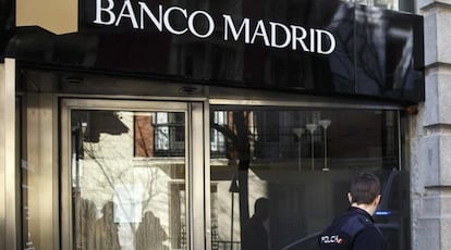 Un polic&iacute;a pasa frente a una oficina de Banco Madrid.