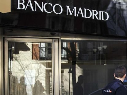 Un polic&iacute;a pasa frente a una oficina de Banco Madrid.