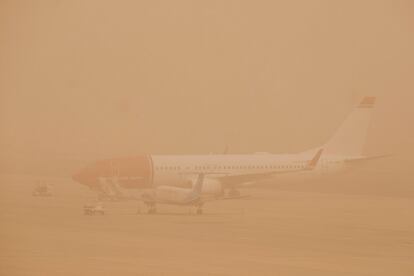 Dos aviones, en el aeropuerto de Gran Canaria, que ha vuelto a quedar este domingo inoperativo por el fuerte viento y la densa calima que afectan a las islas.