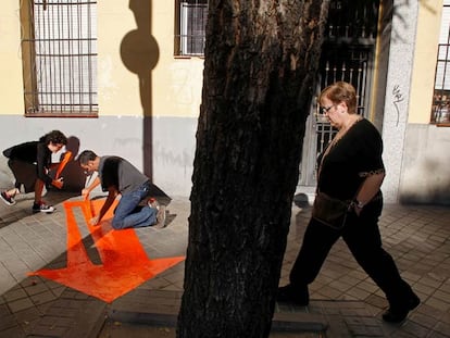 Unos artistas colocan flechas para señalar lugares del distrito de Arganzuela.