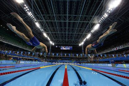 El estadounidense Michael Phelps (izquierda) salta al agua al comienzo de la prueba de 200 metros combinado individual masculino. 