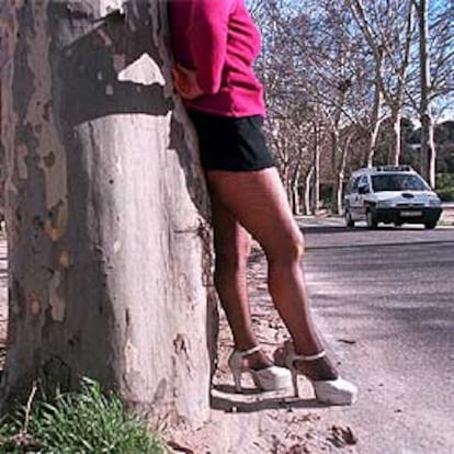 Una prostituta ofrece sus servicios, vigilada por un coche de la policía, en la Casa de Campo.