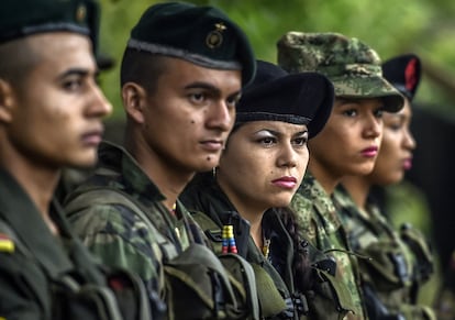 Manuela (C) and other members of the Revolutionary Armed Forces of Colombia (FARC) stand firm during a ceremony at a camp in the Colombian mountains on February 18, 2016. Many of these women are willing to be reunited with the children they gave birth and then left under protection of relatives or farmers, whenever the peace agreement will put an end to the country's internal conflict.    AFP PHOTO / LUIS ACOSTA