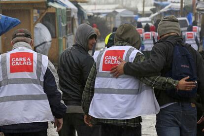Voluntarios de la organización "Care 4 Calais" acompañan a unos inmigrantes que residen en el asentamiento temporal de Calais.