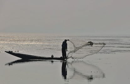 Un pescador de Cachemira echa sus redes en el lago Dal en Srinagar, la capital de verano de la Cachemira india.