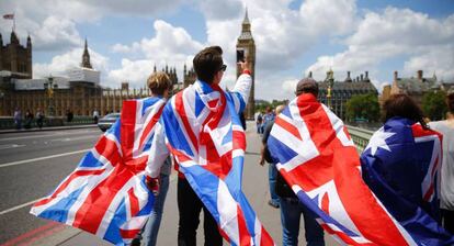 Varias personas caminan sobre el puente de Westminster.