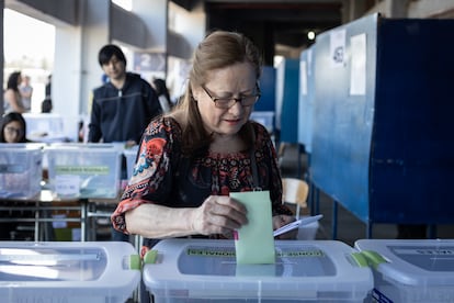 Una mujer deposita sus votos en las urnas durante las elecciones municipales en el Estadio Nacional, en Santiago.