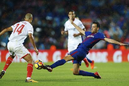 El centrocampista del Sevilla Guido Pizarro pelea el balón ante Sergio Busquets.