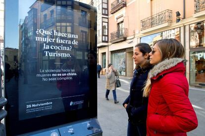 Dos mujeres observan un cartel en Zamora que busca concienciar sobre la violencia machista.