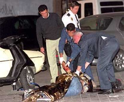 Cuatro policías inspeccionan el cadáver de Elkin Iván Escudero, en el distrito de Ciudad Lineal de Madrid.