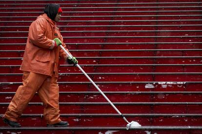 A worker clears the steps of snow on the TKTS booth in New York's Times Square February 17, 2015. REUTERS/Brendan McDermid (UNITED STATESENVIRONMENT - Tags: ENVIRONMENT SOCIETY)