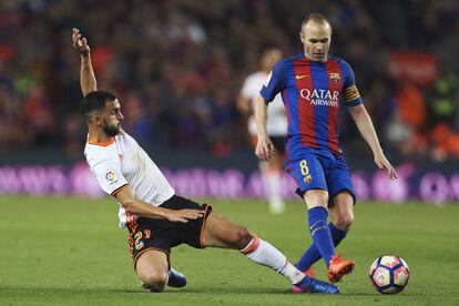 El centrocampista del FC Barcelona Andrés Iniesta (d) lucha el balón con Martín Montoya, del Valencia CF.