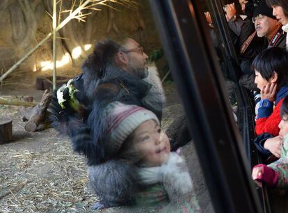 Un grupo de niños sigue una actuación navideña en el Zoo de Tokio.