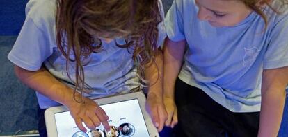 Dos niñas juegan con una tableta en una tienda de juguetes en Barcelona.