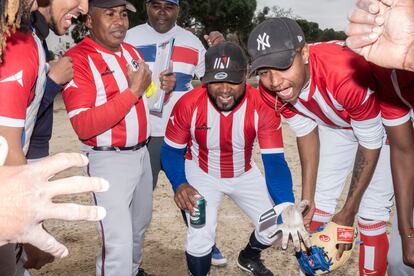 Miembros de un equipo de béisbol dominicano se animan antes de comenzar un partido.

