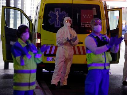 Varios sanitarios se suman al aplauso diario en el exterior del hospital de La Paz, Madrid.