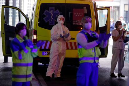 Varios sanitarios se suman al aplauso diario en el exterior del hospital de La Paz, Madrid.