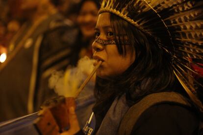 Una mujer indígena fuma en pipa durante la marcha.