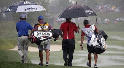 Jerry Kelly y Patric Reed abandonan el campo después de decretarse la suspensión por lluvia.