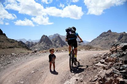 Un participante circula junto a un niño pequeño durante la segunda etapa de la carrera, el 30 de abril de 2018.