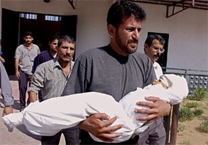 Zakaria Hindi, con el cuerpo sin vida de su hija de dos años, ante la puerta del hospital del campo de refugiados.