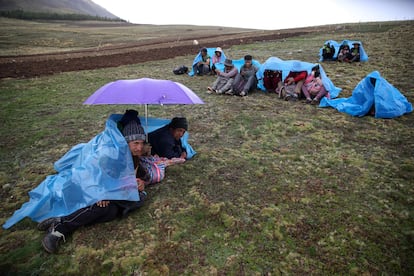 Hace unos meses, los pronósticos no preveían lluvias y las familias aprovecharon para fumigar. Dos días después, cayó una tormenta inesperada que arrastró todo el insecticida que aún no había penetrado en la tierra. Esta lluvia no solo causó una pérdida monetaria, sino que gran parte del cultivo acabó muriendo. En la imagen, un grupo de campesinos se resguarda de la lluvia en la comunidad de San José de Apata. 