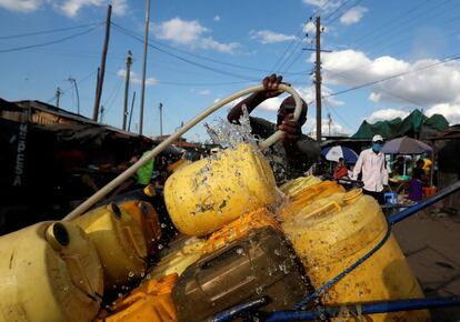 Un vendedor llena bidones con agua para venderlos, en Nairobi, Kenia.