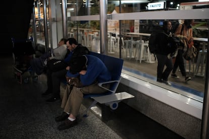 Un hombre que lleva pocos días viviendo en el Aeroparque duerme sobre sus piernas en una de los bancas del lugar.