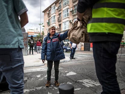 Una mujer recoge una bolsa con comida en el comedor social de la parroquia San Ramón Nonato en Puente de Vallecas.