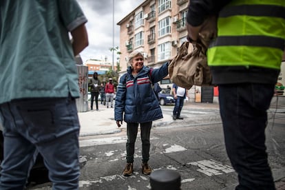 Una mujer recoge una bolsa con comida en el comedor social de la parroquia San Ramón Nonato en Puente de Vallecas.