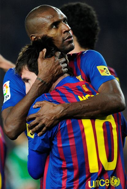 Abidal abraza a Messi tras uno de sus goles al Betis.