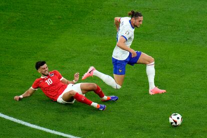 El austriaco Florian Grillitsch, intenta frenar la carrera del francés Adrien Rabiot.