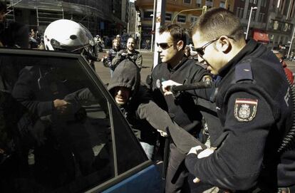 Policías detienen a un hombre durante los incidentes que han protagonizado un grupo de piquetes en la Plaza del Callao.