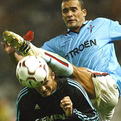 Juanfran trata de golpear el balón por encima de la cabeza de Beckham.
